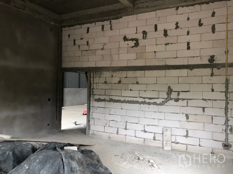 Warehouse for rent in Lam Luk Ka, Pathum Thani - Unfinished office room with block walls and conduit inside the warehouse.