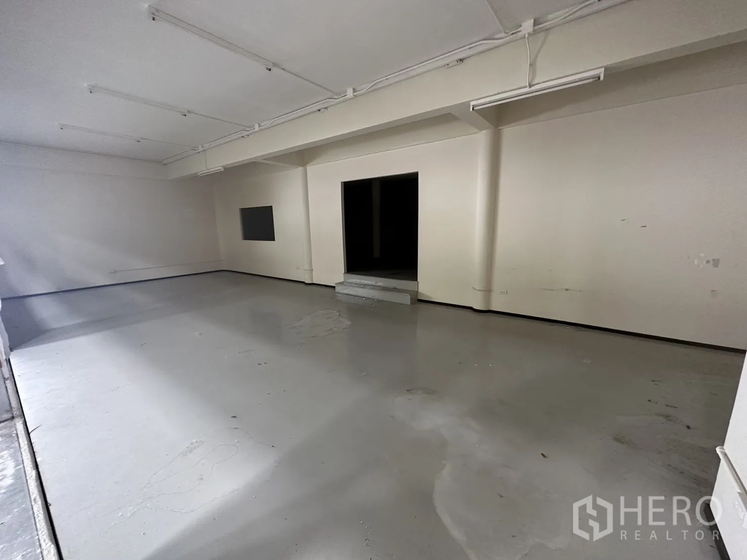 Warehouse for rent in Suan Luang, Bangkok - Large flexible workspace with polished floor and fluorescent lighting.