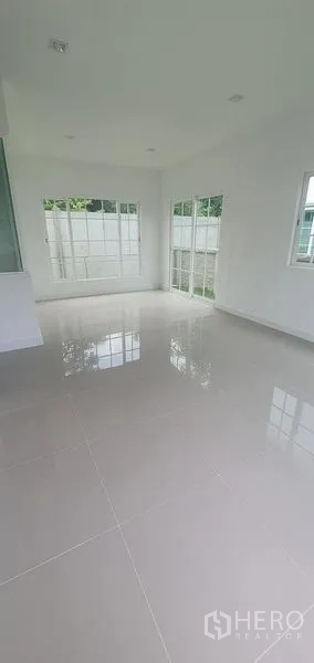 Detached House for rent in Nonthaburi - Sunlit corner of the living space with large windows and garden access in Pak Kret, Nonthaburi.