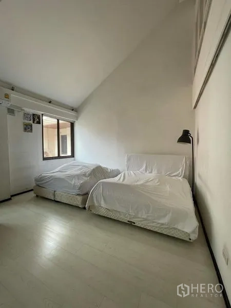Townhouse for sale - Bedroom with two beds and a high vaulted ceiling.