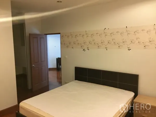 公寓 出租或出售在Khlong Toei, Bangkok - 主卧配双人床、床头板与花纹装饰墙纸。