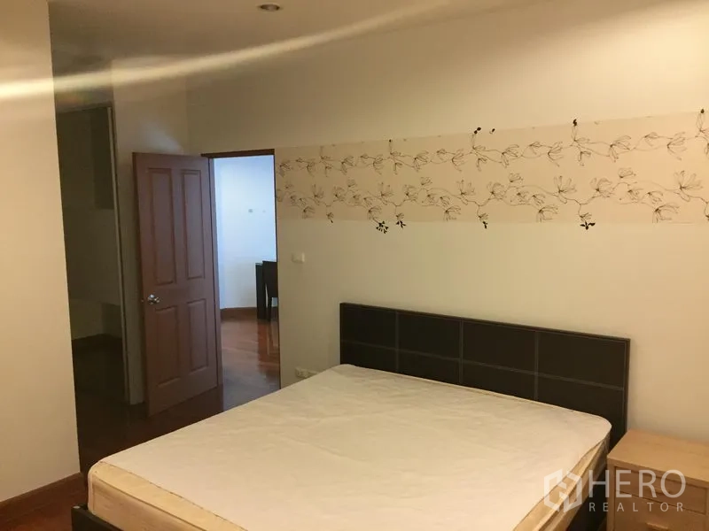 公寓 出租或出售在Khlong Toei, Bangkok - 主卧配双人床、床头板与花纹装饰墙纸。