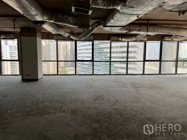 办公空间 出租 - 开放式办公楼层，外露空调管道与全景窗，面向素坤逸高楼。