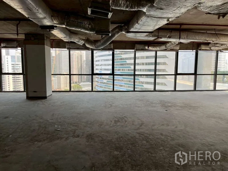 办公空间 出租 - 开放式办公楼层，外露空调管道与全景窗，面向素坤逸高楼。