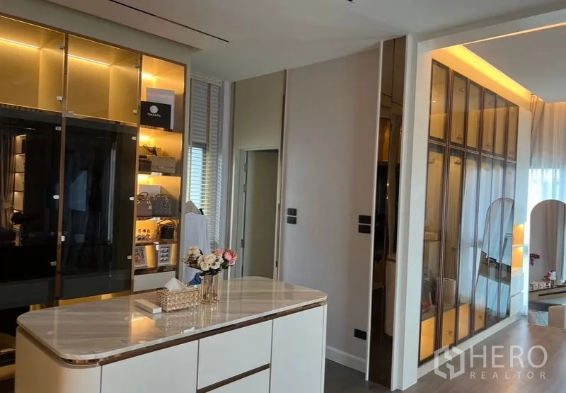 独立式住宅 出售在Bang Kapi, Bangkok - 更衣室设中央岛台与展示柜，灯光温暖柔和。