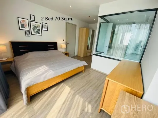 公寓 出租在Watthana, Bangkok - 主卧带玻璃墙卫浴与木质家具，自然采光充足，位于瓦他那区公寓。