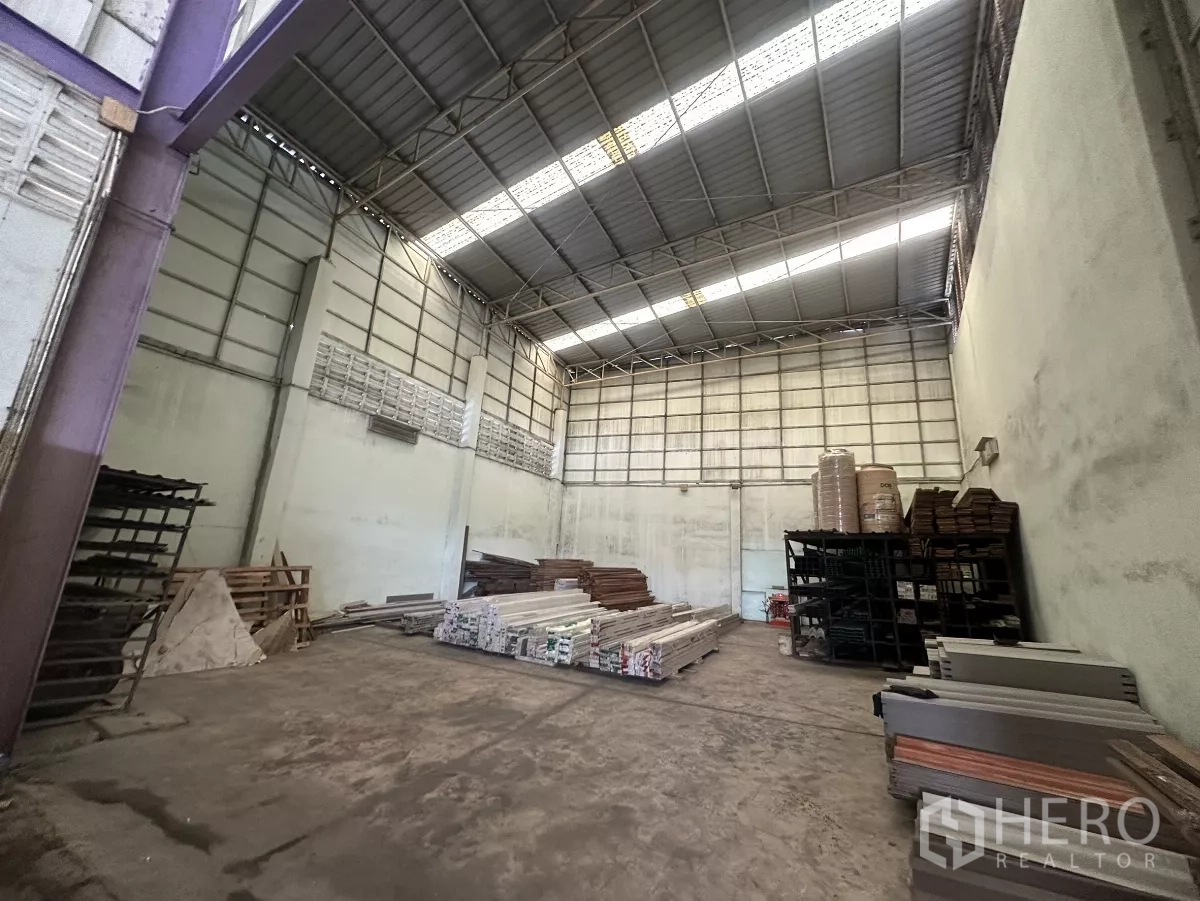 Warehouse for rent in Mueang Nonthaburi, Nonthaburi - Clear open storage area inside the warehouse with skylights, tall walls and steel racks.