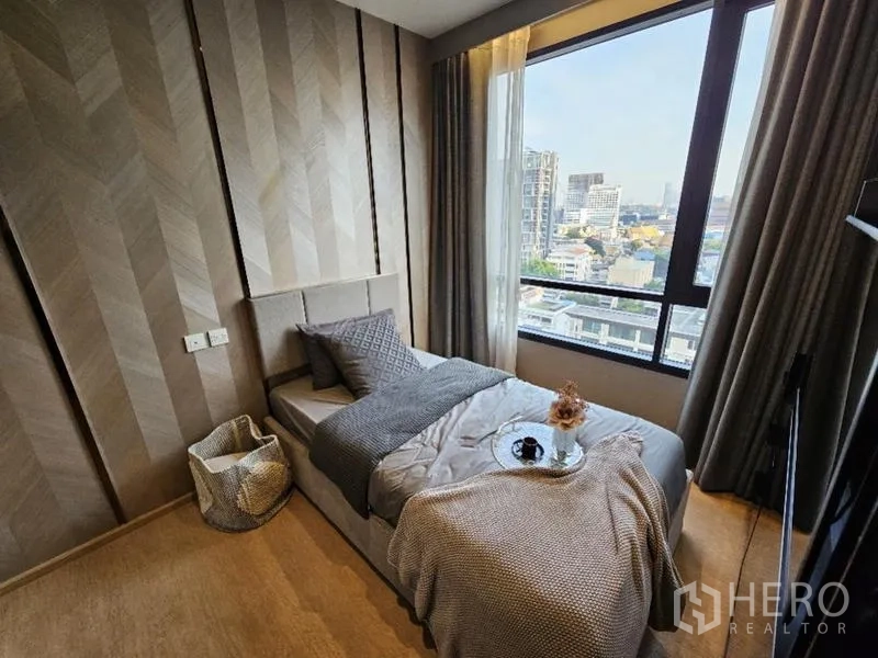 Condominium for rent - Second bedroom with single bed by window and skyline outlook.