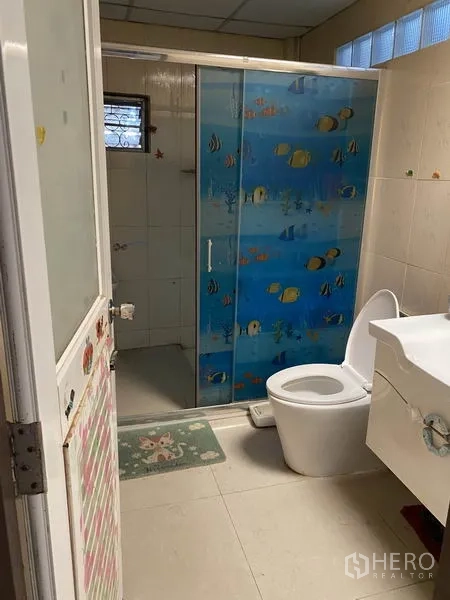 Townhouse for rent in Lat Phrao, Bangkok - Bathroom with glass shower enclosure, toilet, and vanity unit.