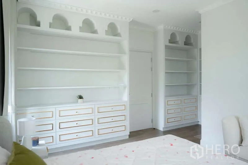 Detached House for rent or sale in Saphan Sung, Bangkok - Built-in white shelving and drawers providing ample bedroom storage.