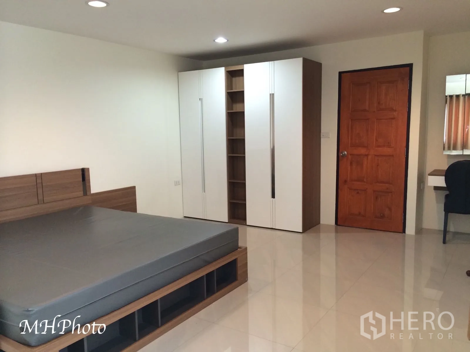 Condominium for rent in Watthana, Bangkok - Large bedroom with modern bedframe, built-in wardrobe and glossy tile flooring.