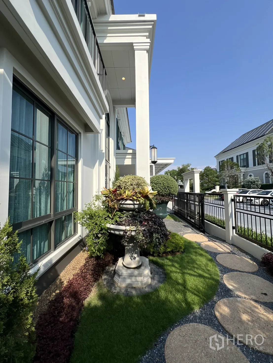 独栋房屋 for rent in Bang Phli, Samut Prakan - 前庭花园，修剪草坪、踏步小径与白色外立面细节。