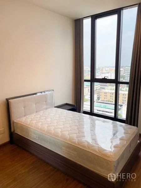 公寓 出售在Watthana, Bangkok - 次卧配单人床，靠全高窗，俯瞰城市景色。