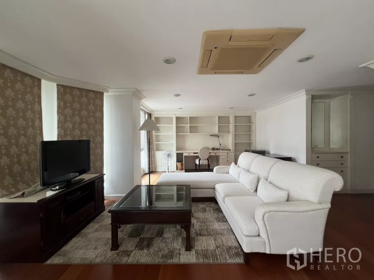 Townhouse for sale in Watthana, Bangkok - Lounge and study space with white sofa, TV console and work desk.