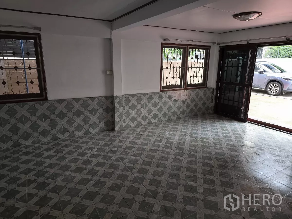 带办公室的家 出租在Wang Thonglang, Bangkok - 一层起居区，花纹地砖，防盗窗与双开门通向车道