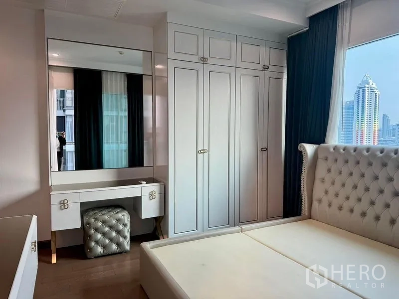 公寓 出售在Ratchathewi, Bangkok - 卧室配纽扣绒面床、通顶衣柜与梳妆台，可望城市景观。