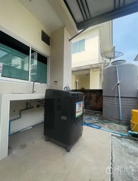 Detached House for rent in Bang Phli, Samut Prakan - Outdoor utility area with sink, washing machine and large water storage tank.