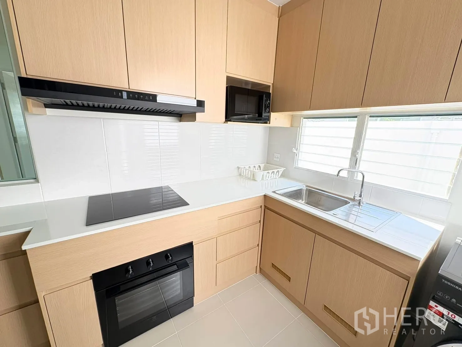 บ้าน for rent in Bang Phli, Samut Prakan - มุมครัวใกล้ชิดกับเตาอบ ไมโครเวฟ เตาไฟฟ้า และอ่างล้างจานใต้หน้าต่าง