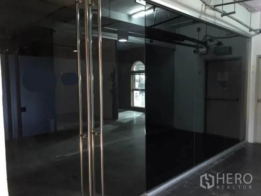 办公空间 出租在Watthana, Bangkok - 玻璃立面与双开门的办公室入口，外露天花设计