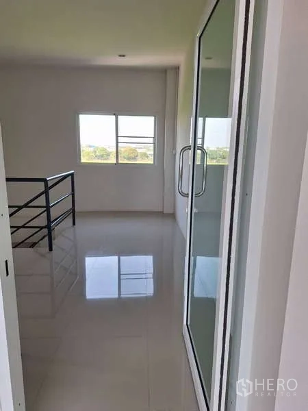 货栈 出售在Pathum Thani - 二楼明亮的办公室走廊，玻璃门与窗户采光充足。