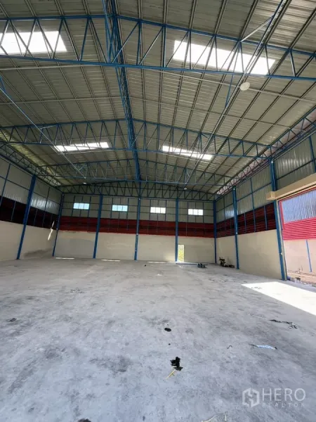 Warehouse for rent in Lam Luk Ka, Pathum Thani - Spacious warehouse interior showing an 11 m high steel truss roof with skylights.