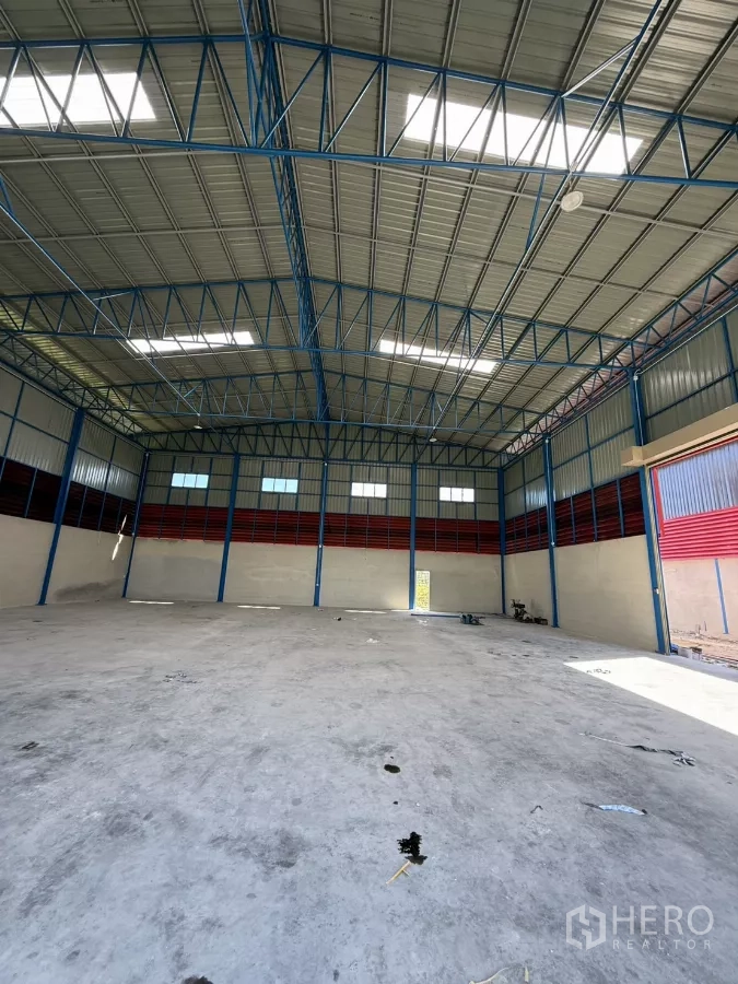 Warehouse for rent in Lam Luk Ka, Pathum Thani - Spacious warehouse interior showing an 11 m high steel truss roof with skylights.