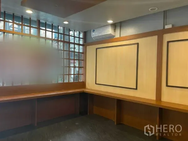 Retail Space for rent in Watthana, Bangkok - Interior corner with built-in wooden counter, grid windows and air-conditioning, ideal for a service counter.