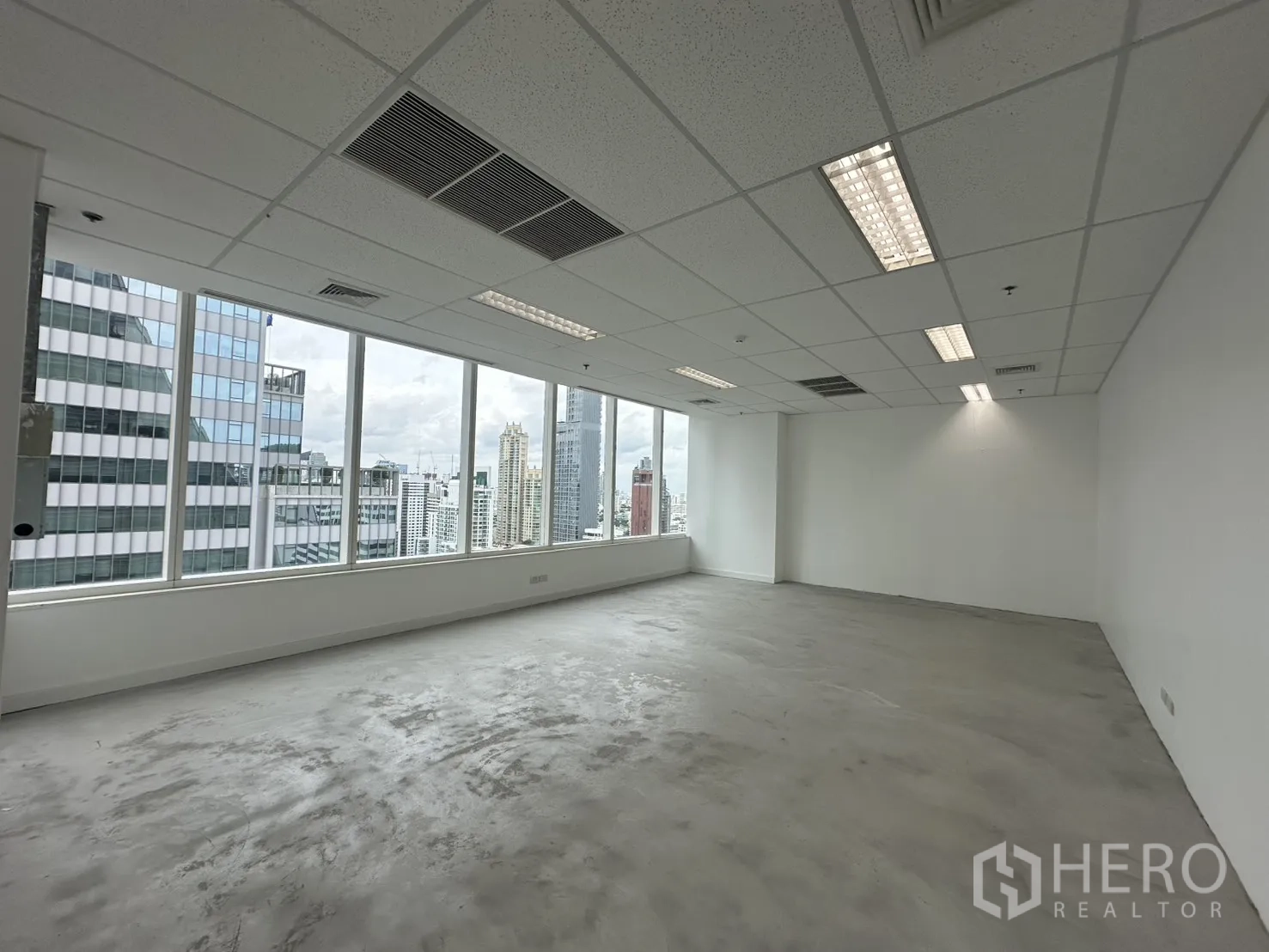 办公室 for rent in Watthana, Bangkok - 宽敞的转角办公区，设有空调出风口和日光灯照明。
