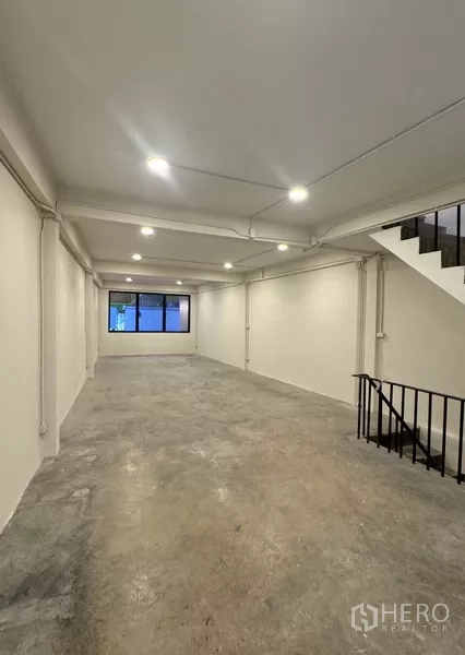 Shophouse for rent - Open‑plan floor with LED downlights and staircase, unfinished concrete floor ready for fit‑out.