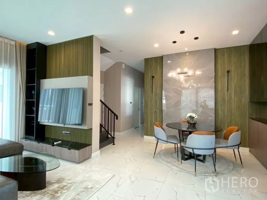 บ้าน ให้เช่าในBang Phli, Samut Prakan - โถงนั่งเล่น–ทานอาหาร พื้นลายหินอ่อน ผนังทีวี และโต๊ะกลมพร้อมโคมไฟโมเดิร์น