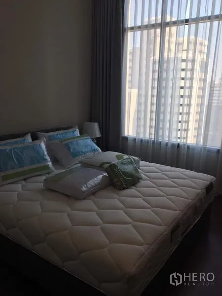 公寓 出租在Watthana, Bangkok - 明亮卧室，配特大床与纱帘，可眺望曼谷天际线。