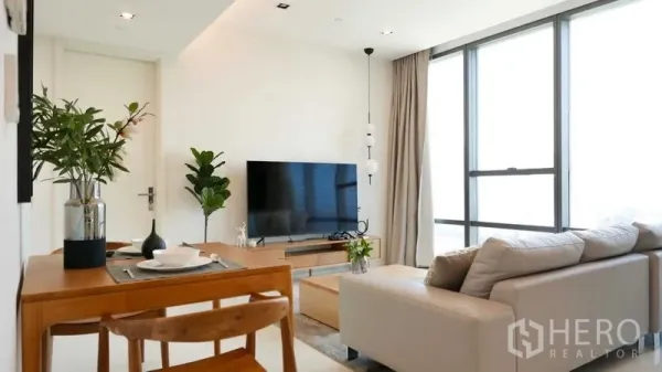คอนโด ให้เช่าในSathon, Bangkok - ห้องนั่งเล่นสว่าง โซฟา ทีวี โต๊ะทานอาหาร และหน้าต่างกระจกเต็มบานในคอนโดสาทร