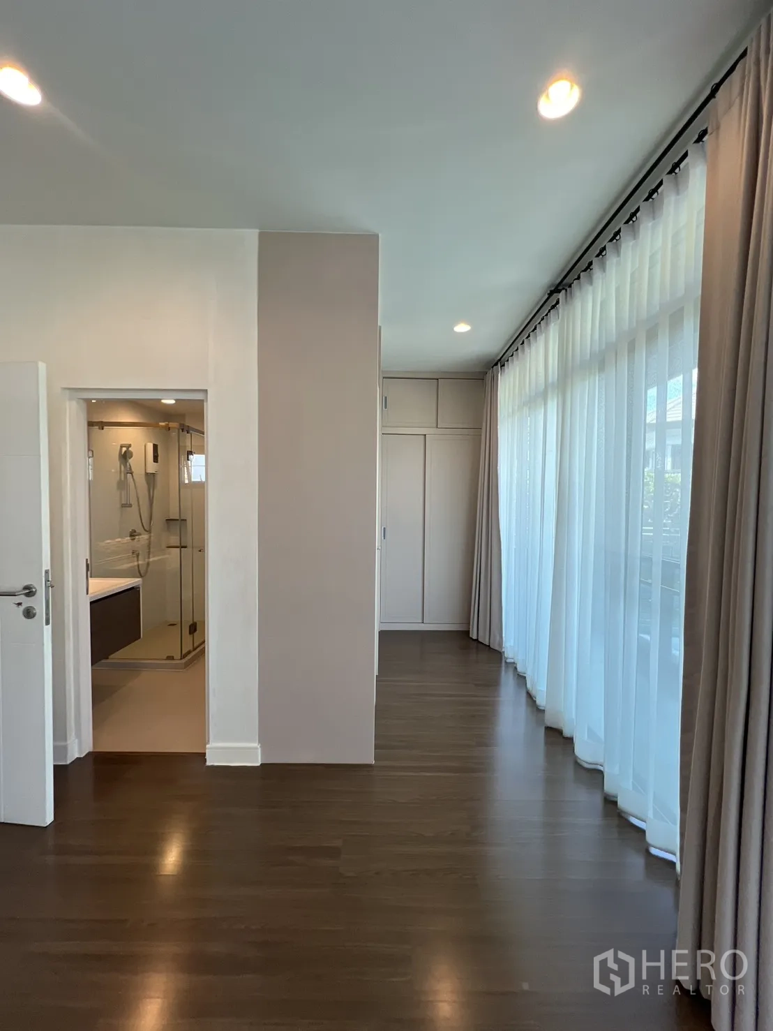 Detached House for sale in Bang Kapi, Bangkok - Master bedroom with wide windows and balcony door.