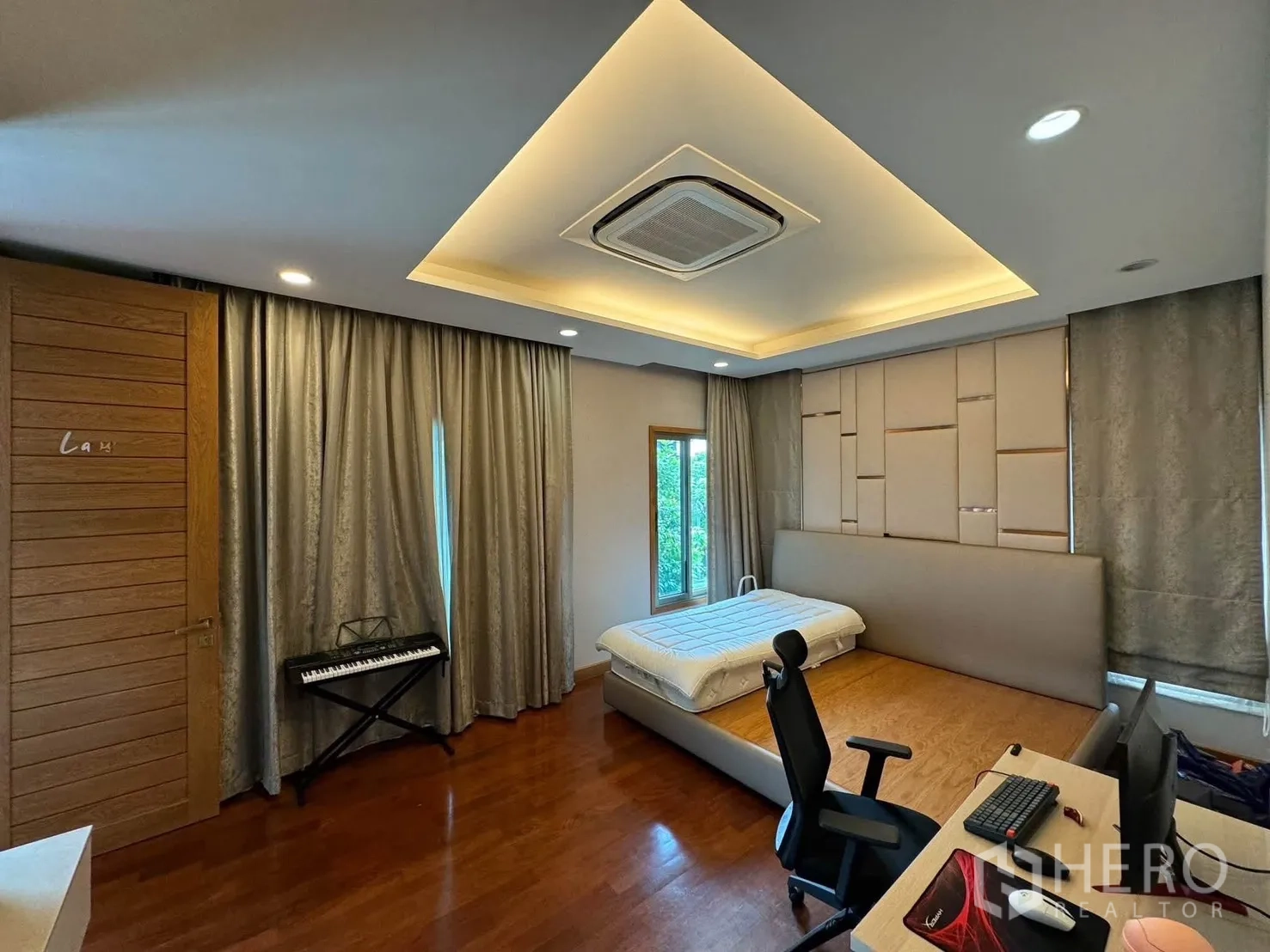 Detached House for rent in Prawet, Bangkok - Spacious bedroom with platform bed, desk and ceiling lighting.