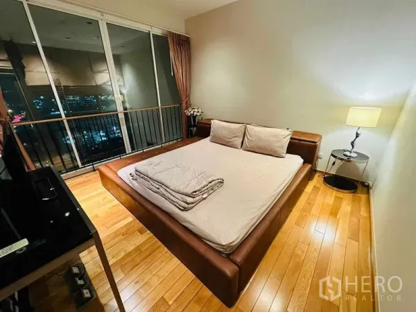 公寓 出租在Bangkok - 宽敞卧室，皮床与床头灯，整面玻璃俯瞰曼谷