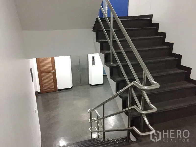 办公空间 出租在Khlong Toei, Bangkok - 室内楼梯配不锈钢扶手，通向走廊与电梯厅。