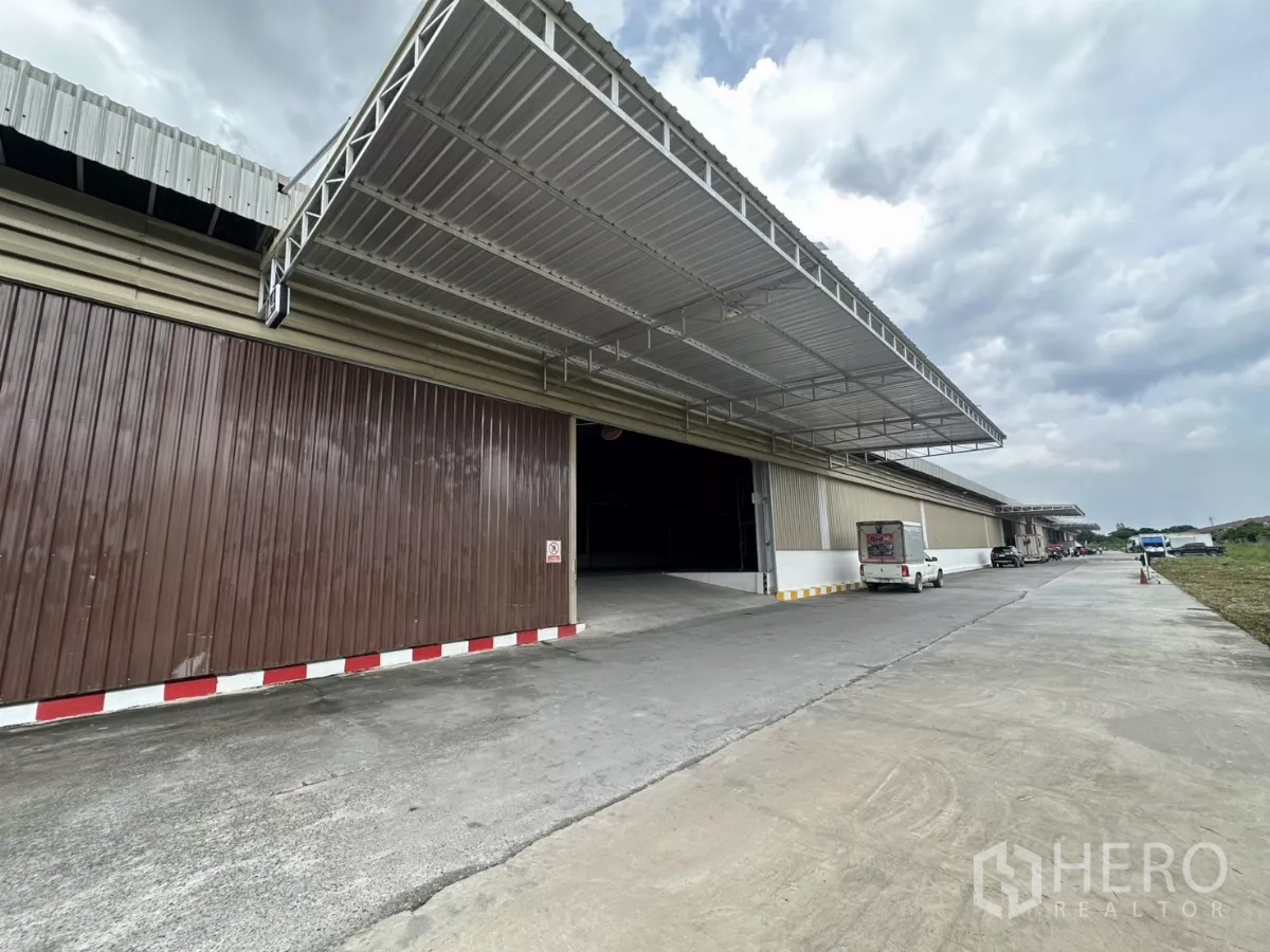 Warehouse for rent in Lat Krabang, Bangkok - Row of dock-high loading bays with canopy, elevated ramp and truck parking lane outside the warehouse.