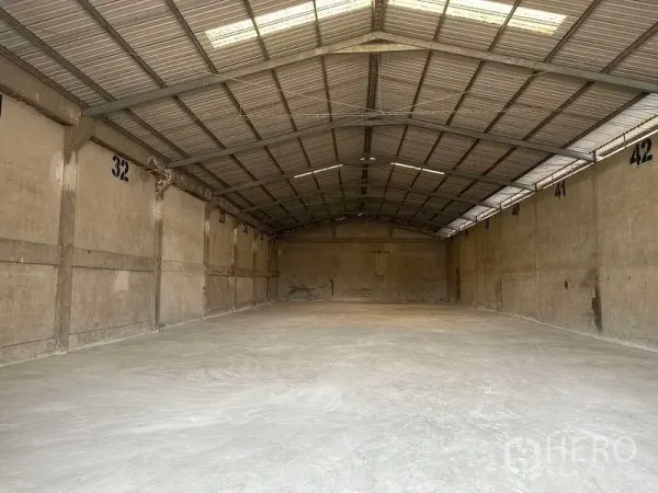 Factory for rent or sale in Bang Phli, Samut Prakan - Empty warehouse bay with gabled metal roof, skylights and smooth concrete floor.