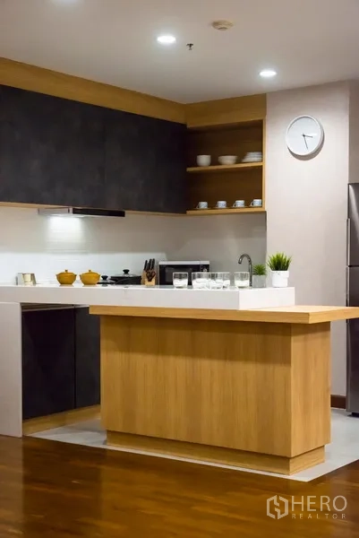Condominium for rent in Pathum Wan, Bangkok - Modern kitchen with island, open shelving, stone countertop and stainless refrigerator.
