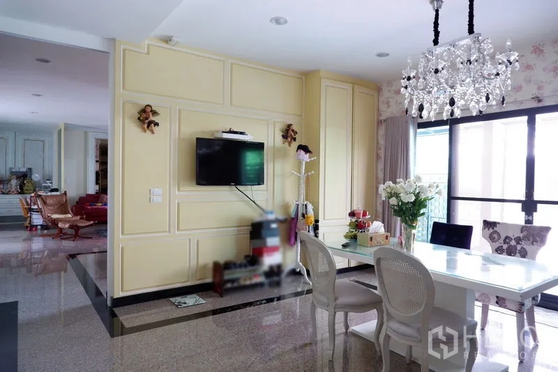 Detached House for sale in Saphan Sung, Bangkok - Bright dining area with crystal chandelier, TV wall paneling and sliding glass doors.