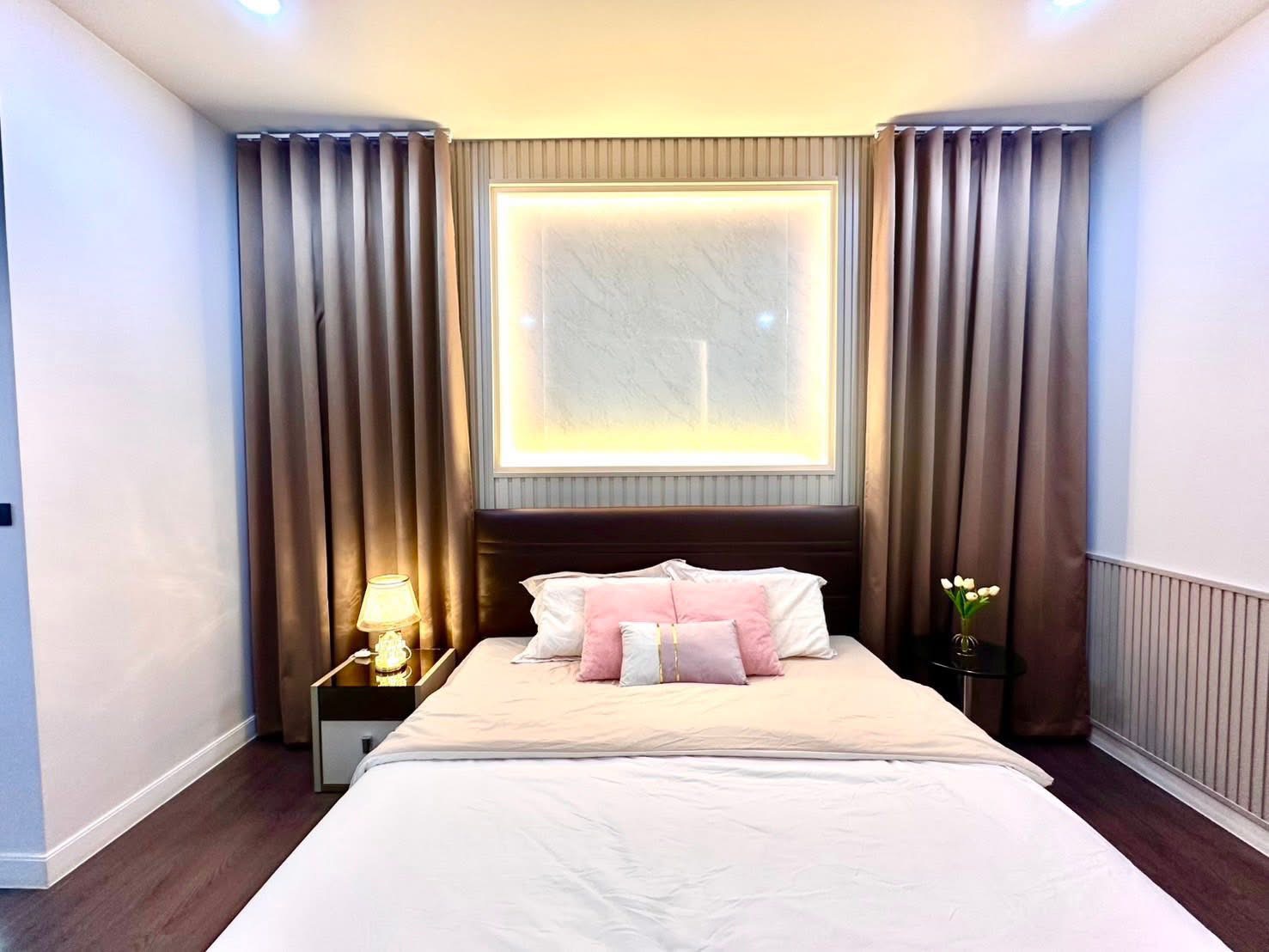 Detached House for rent in Bang Kapi, Bangkok - Cozy bedroom headboard with warm backlit wall art and double curtains.