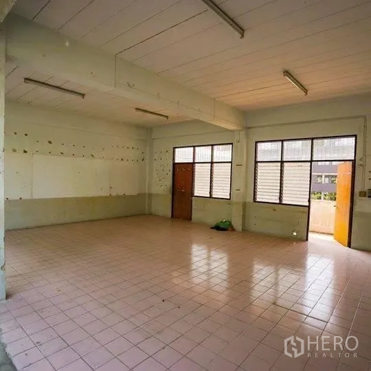 Retail Space for rent in Watthana, Bangkok - Unfurnished retail interior with tiled floor, fluorescent ceiling lights, windows and a wooden door, ready for fit-out.