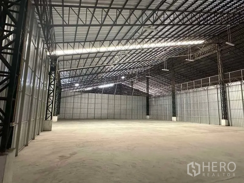 Warehouse for rent in Mueang Pathum Thani, Pathum Thani - Bright storage space with steel truss ceiling, LED lighting, and durable concrete surface.