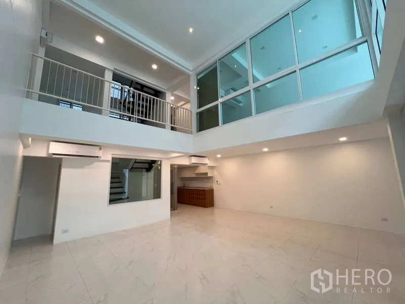 带办公室的家 出租在Khlong Toei, Bangkok - 双层挑高客厅，设夹层走廊与室内玻璃墙。