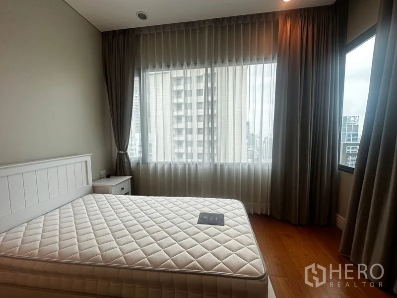 Condominium for rent in Khlong Toei, Bangkok - Corner bedroom with queen bed, two large windows and city outlooks.