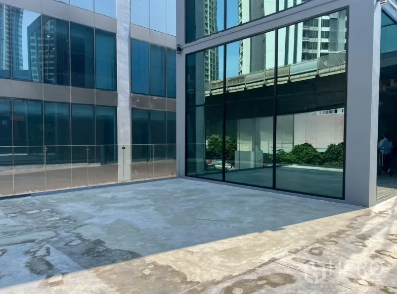 零售空间 for rent in Khlong Toei, Bangkok - 现代感玻璃立面商用建筑，前方设有宽阔露天前庭。