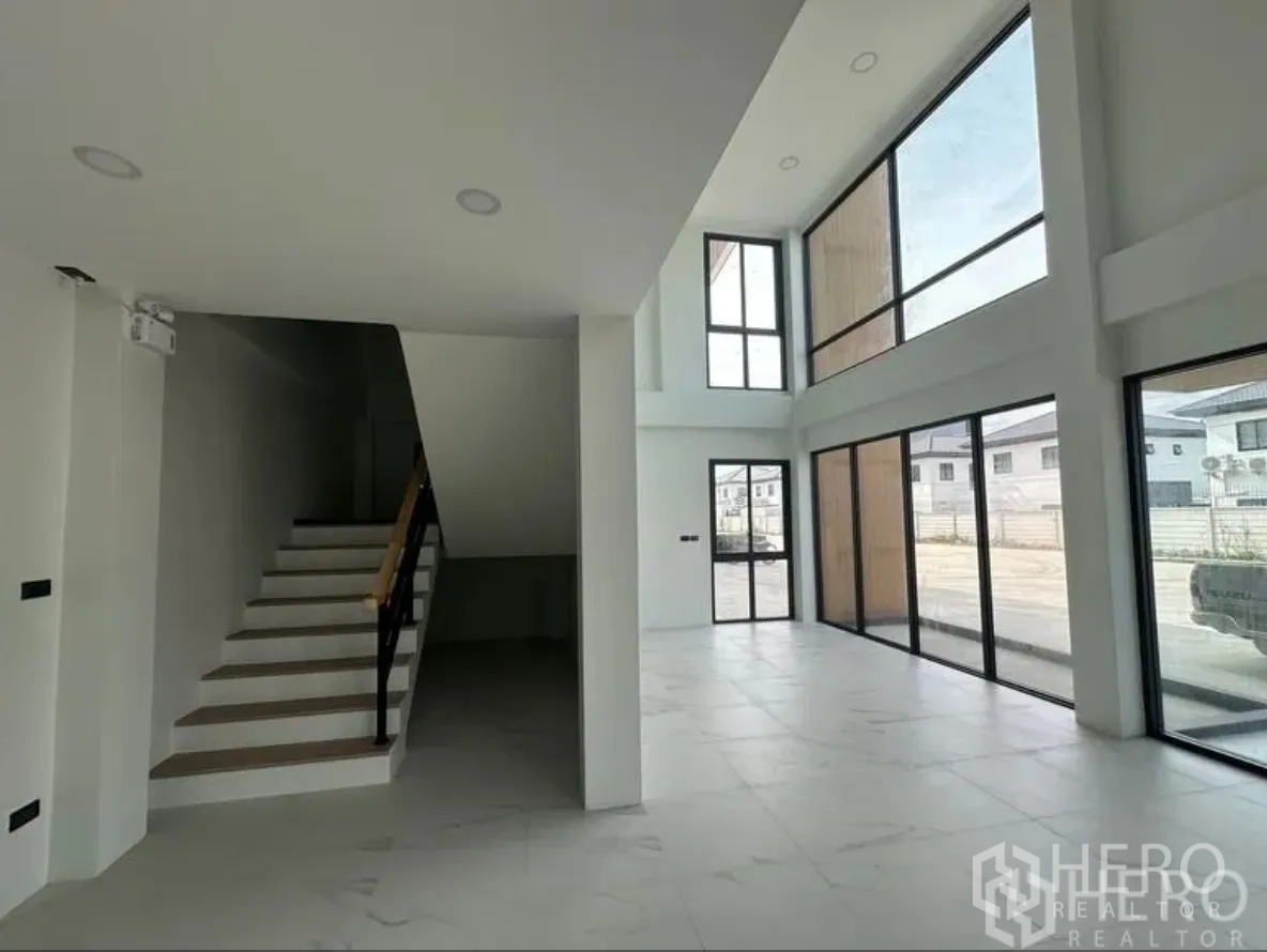 仓库 for sale in Lam Luk Ka, Pathum Thani - 一层办公室与楼梯相邻，整面玻璃面向车道。