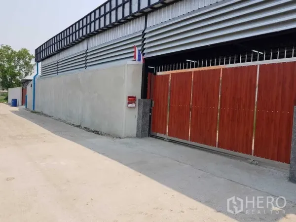 คลังสินค้า ขายในLam Luk Ka, Pathum Thani - ด้านหน้าทรัพย์สิน ประตูสไลด์ลายไม้ติดถนนซอยเงียบ