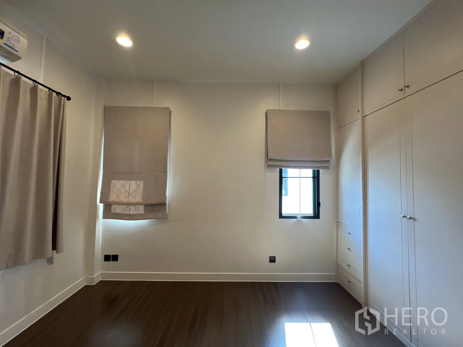 Detached House for sale in Bang Kapi, Bangkok - Bedroom with built-in wardrobes and two windows.