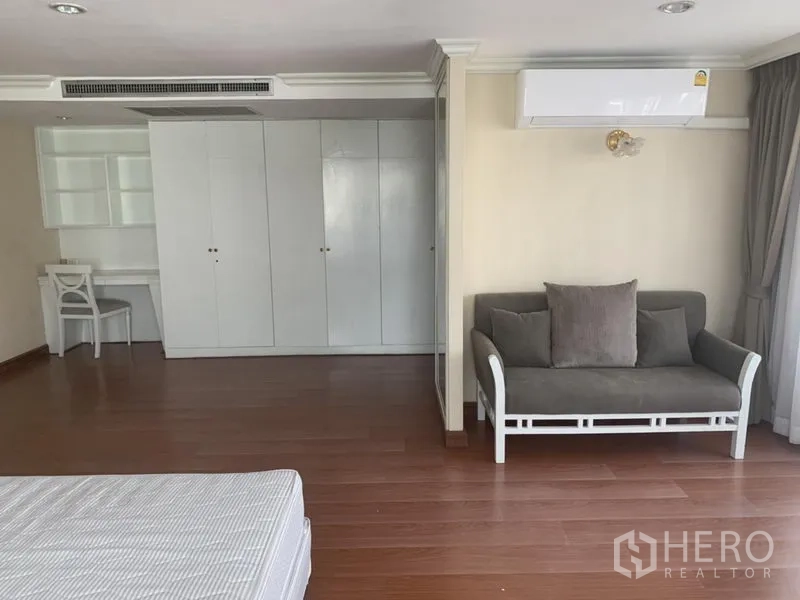 公寓 出租在Watthana, Bangkok - 主卧套间设衣柜、书桌、小沙发与空调。